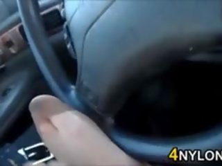 Erting henne føtter i strømpebukse i en bil